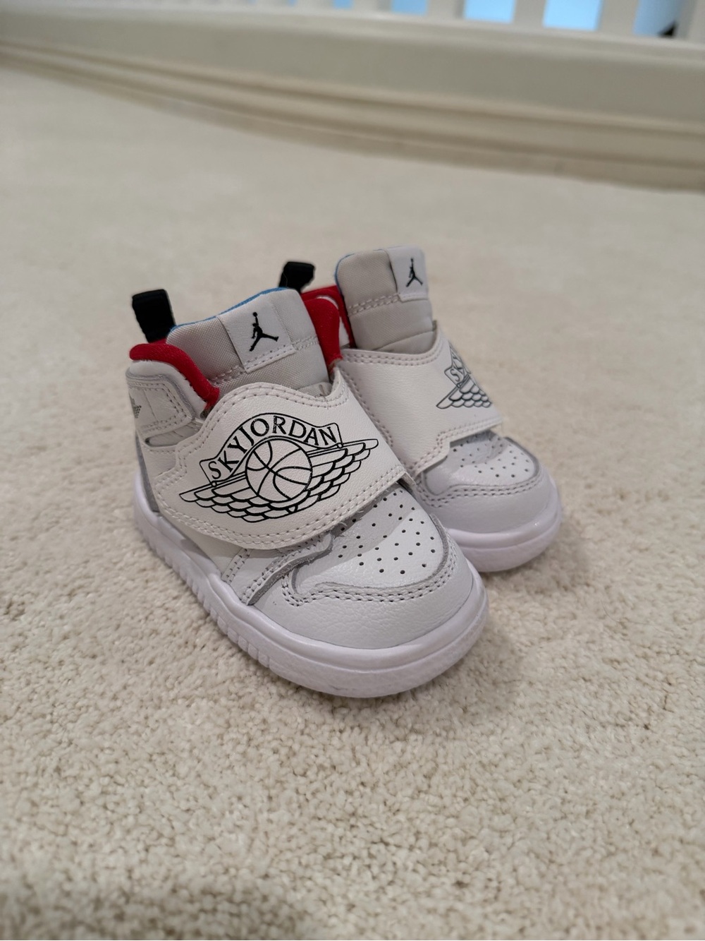 Jordan White Kids Sneakers with Red & Light Blue Accents